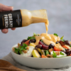 French dressing being poured onto a goats cheese salad