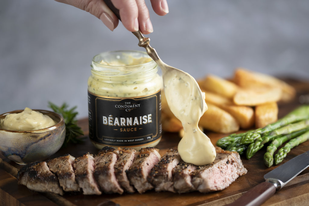 Bearnaise sauce being spooned over a steak