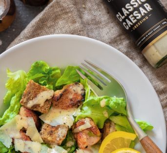 Caesar Salad Dressing with grilled chicken and salad on a plate