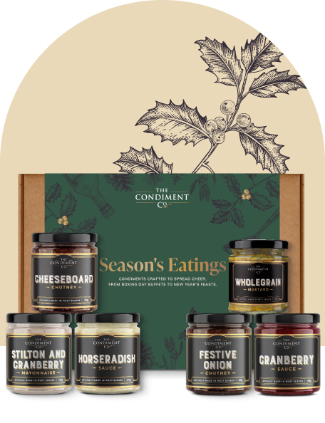 Festive collection gift box with six products stacked beside it.